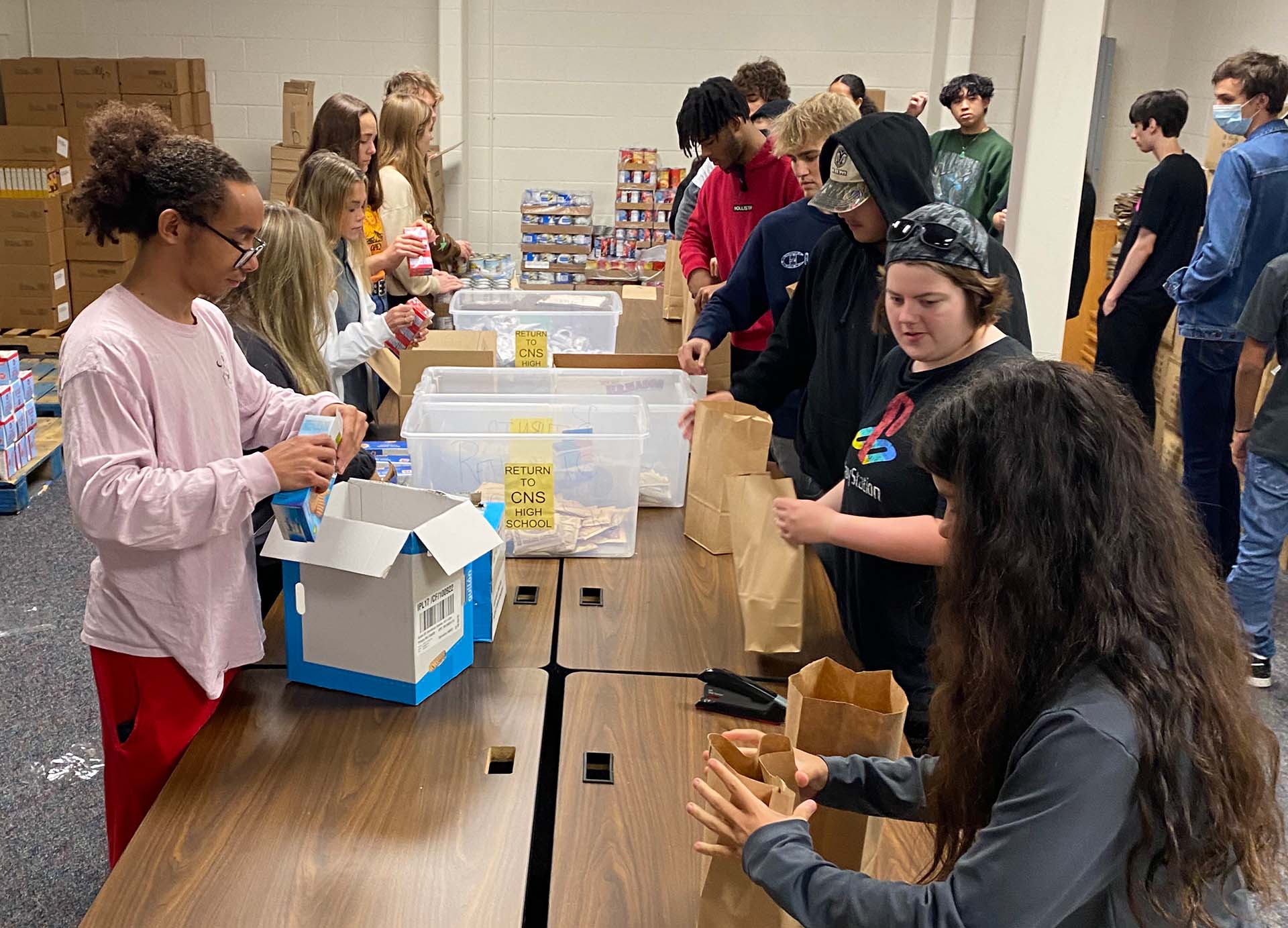 C-NS seniors packing food bags for district families as part of their Participation in Government class.