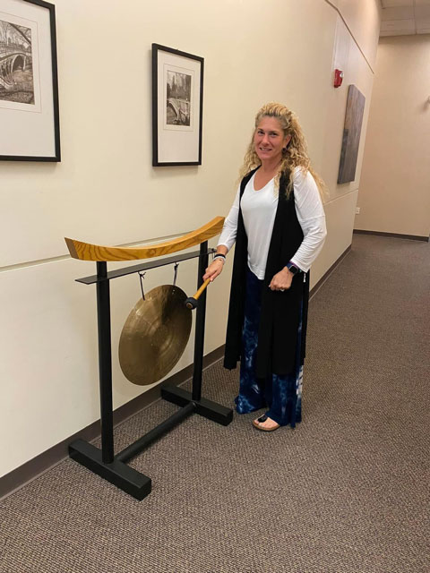 Sarah Wise, member of the Hewlett-Woodmere Faculty Association, rings the gong at her doctor’s office, signifying the successful conclusion of her breast cancer treatment.